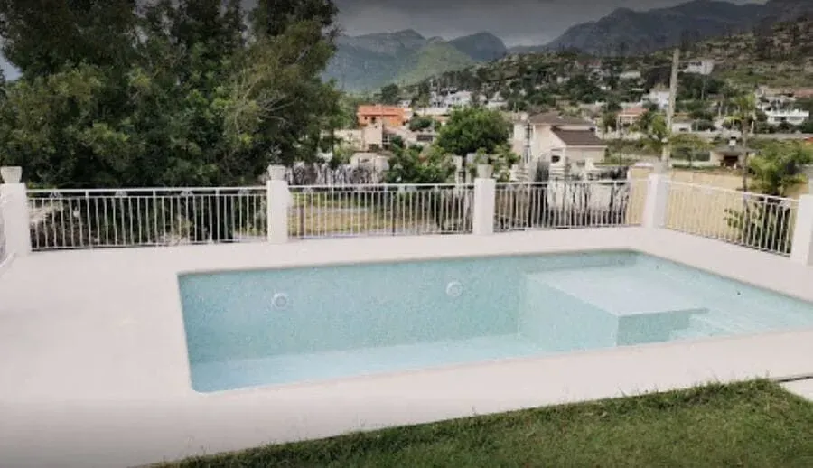 Una gran piscina se encuentra encima de un exuberante césped verde.