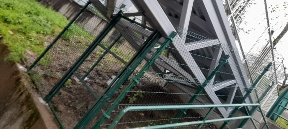 Un puente con una valla verde que lo rodea.