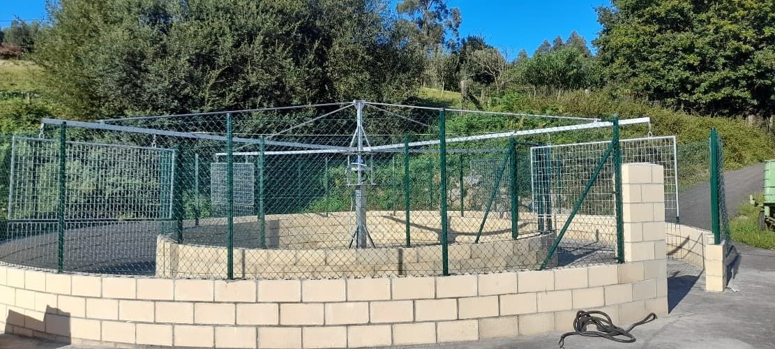 Una pared de ladrillos con una valla de alambre a su alrededor.