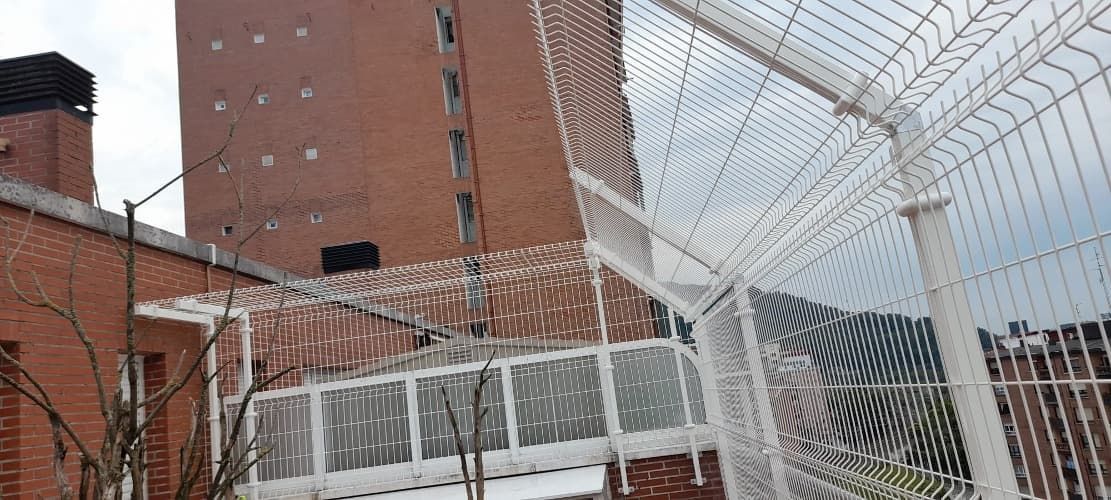 Una valla de alambre de púas rodea un edificio de ladrillo.