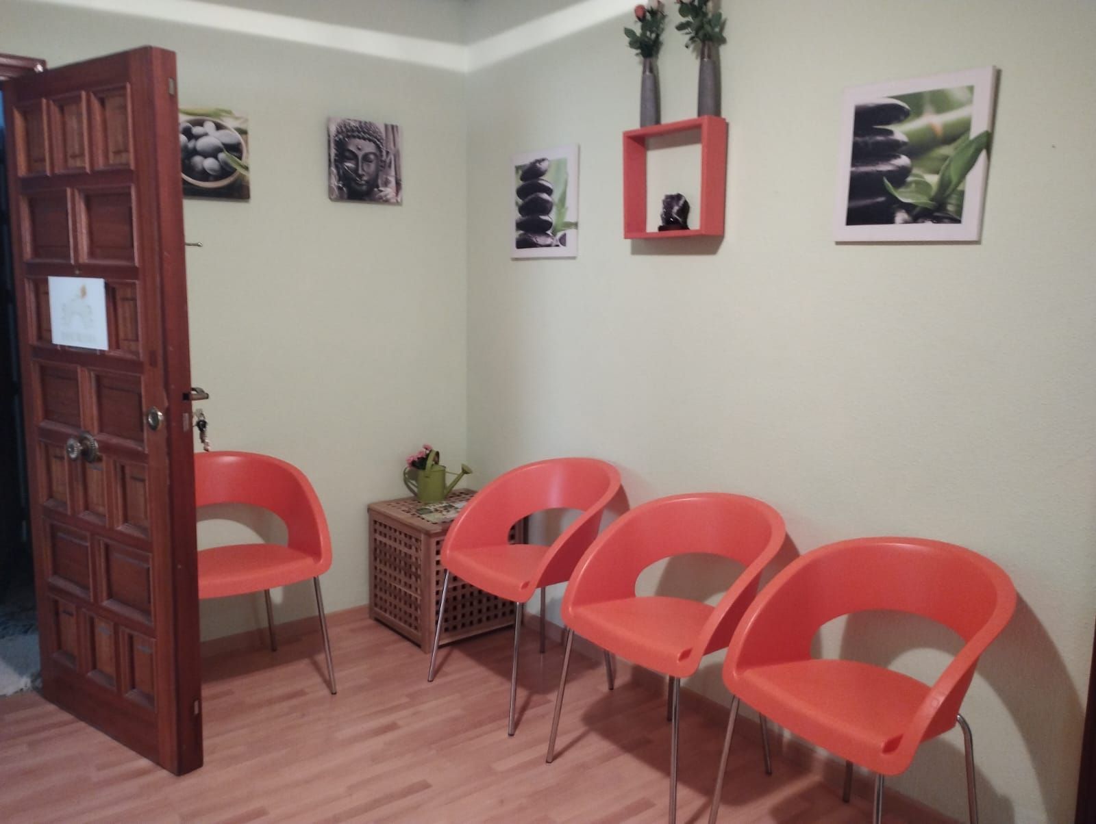 Una persona con jeans rotos se sienta frente a alguien que escribe en un portapapeles; habitación blanca y luminosa.