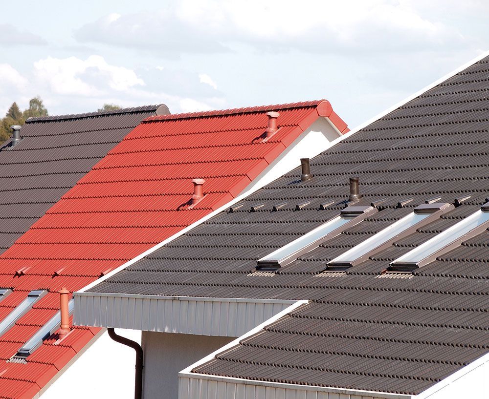 Eine Reihe von Häusern mit roten und schwarzen Dächern, 