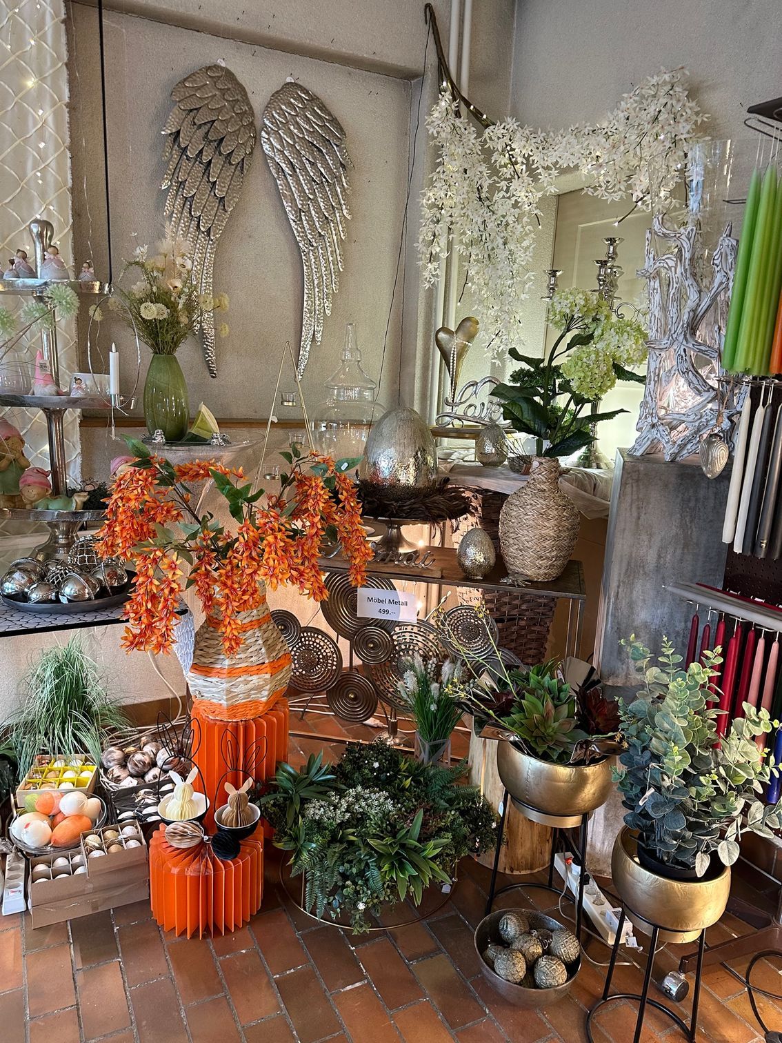 Ein Raum mit vielen Topfpflanzen und einem Spiegel.