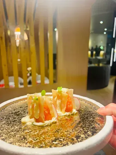 Plat dans une assiette dorée et cloison en bois en arrière-plan