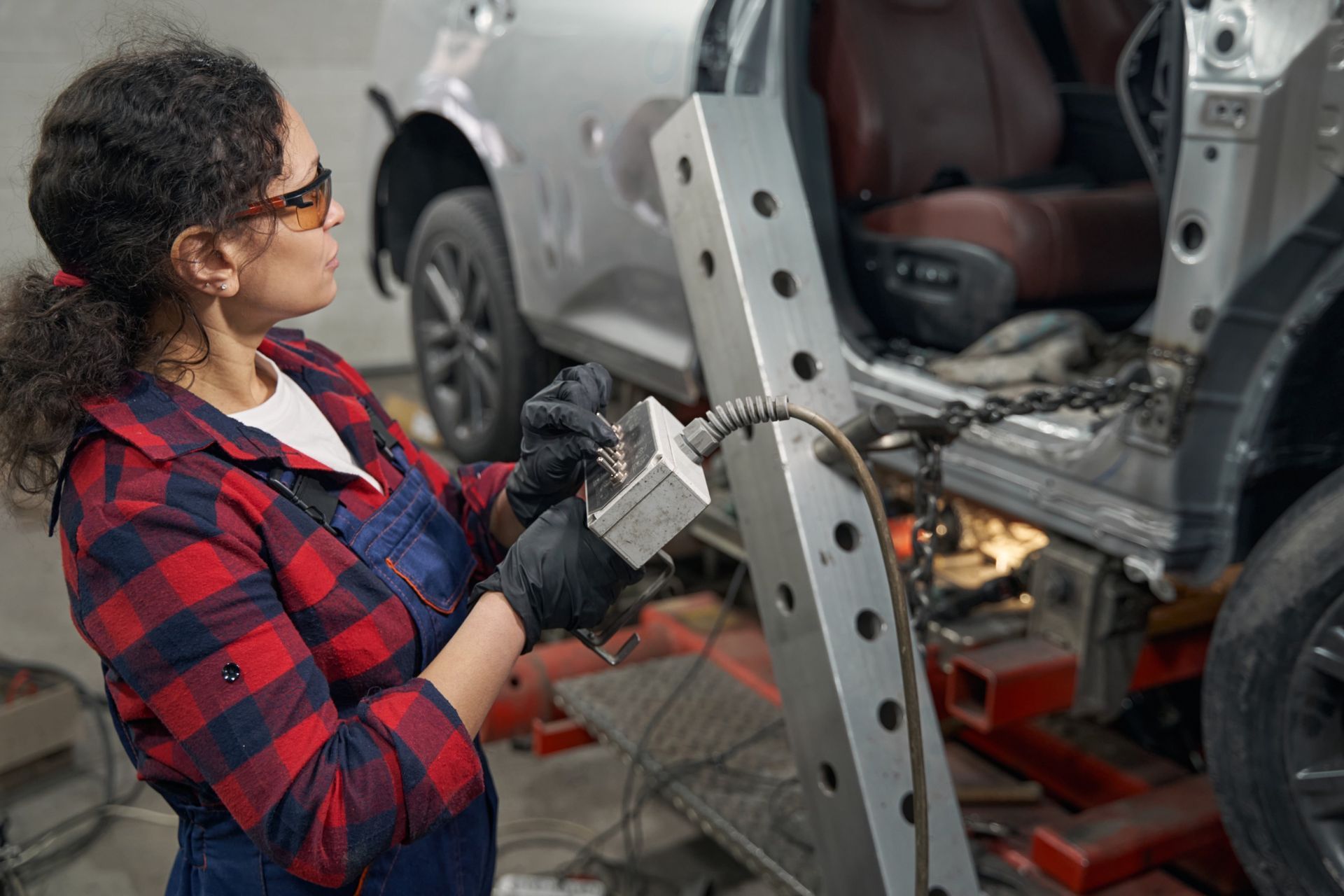 Una mujer está trabajando en un coche en un garaje.