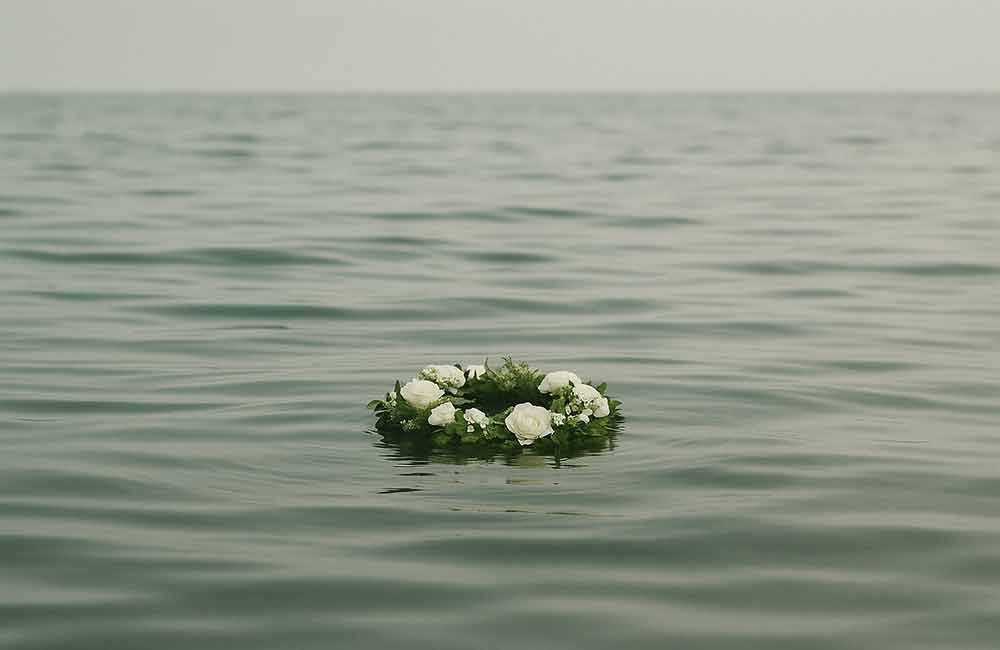 Ein Blumenkranz schwimmt im Meer.