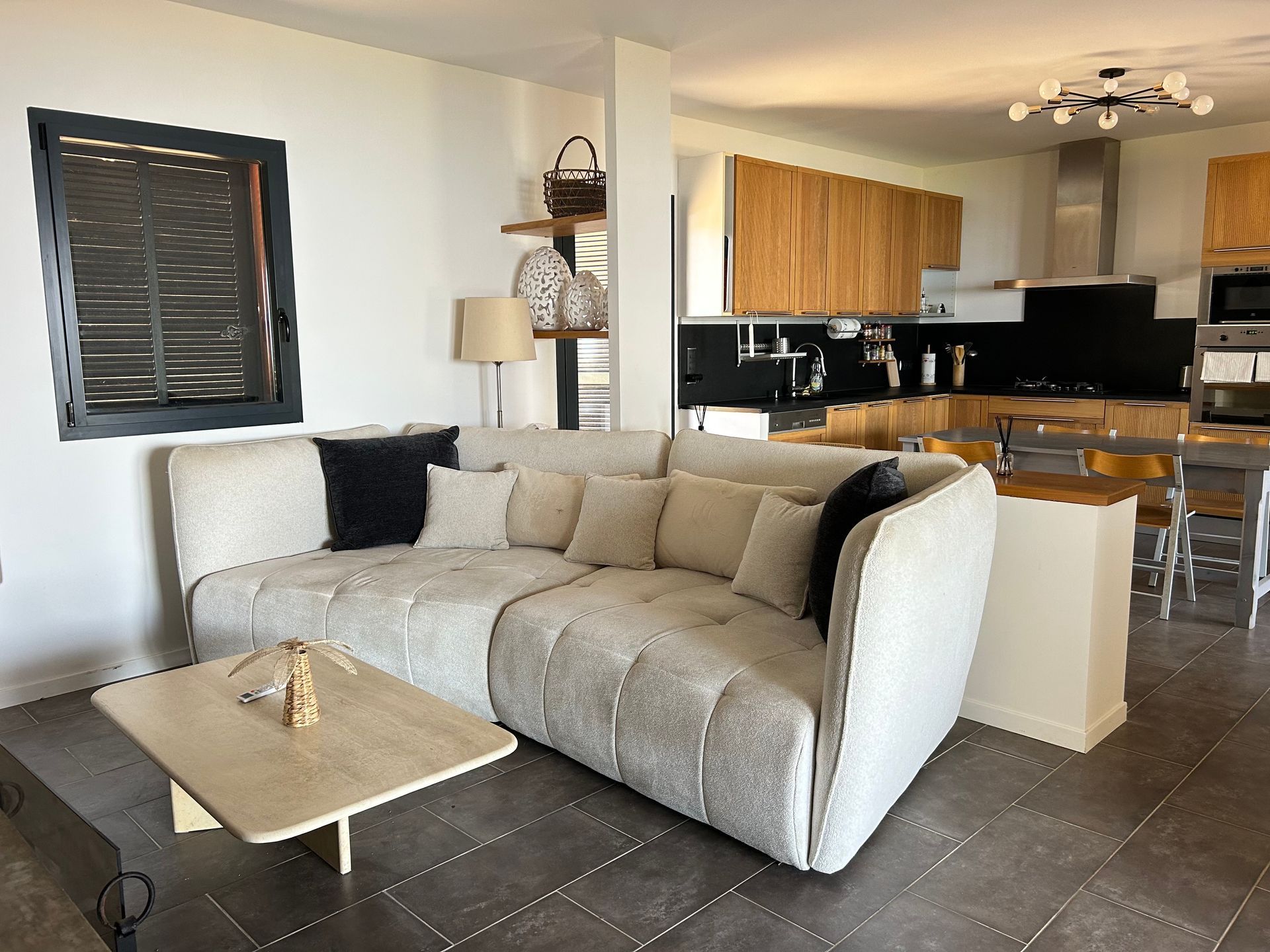 Un séjour avec un canapé et une cuisine en arrière plan