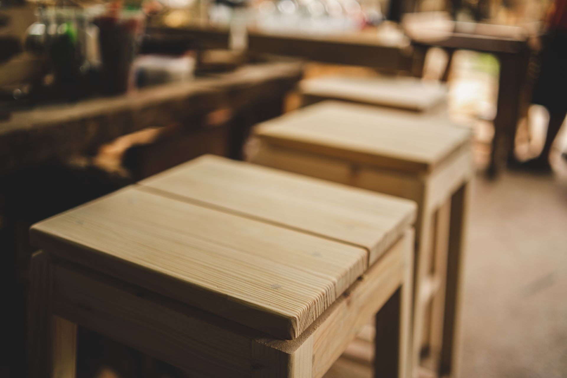 Trois tabourets en bois clair alignés