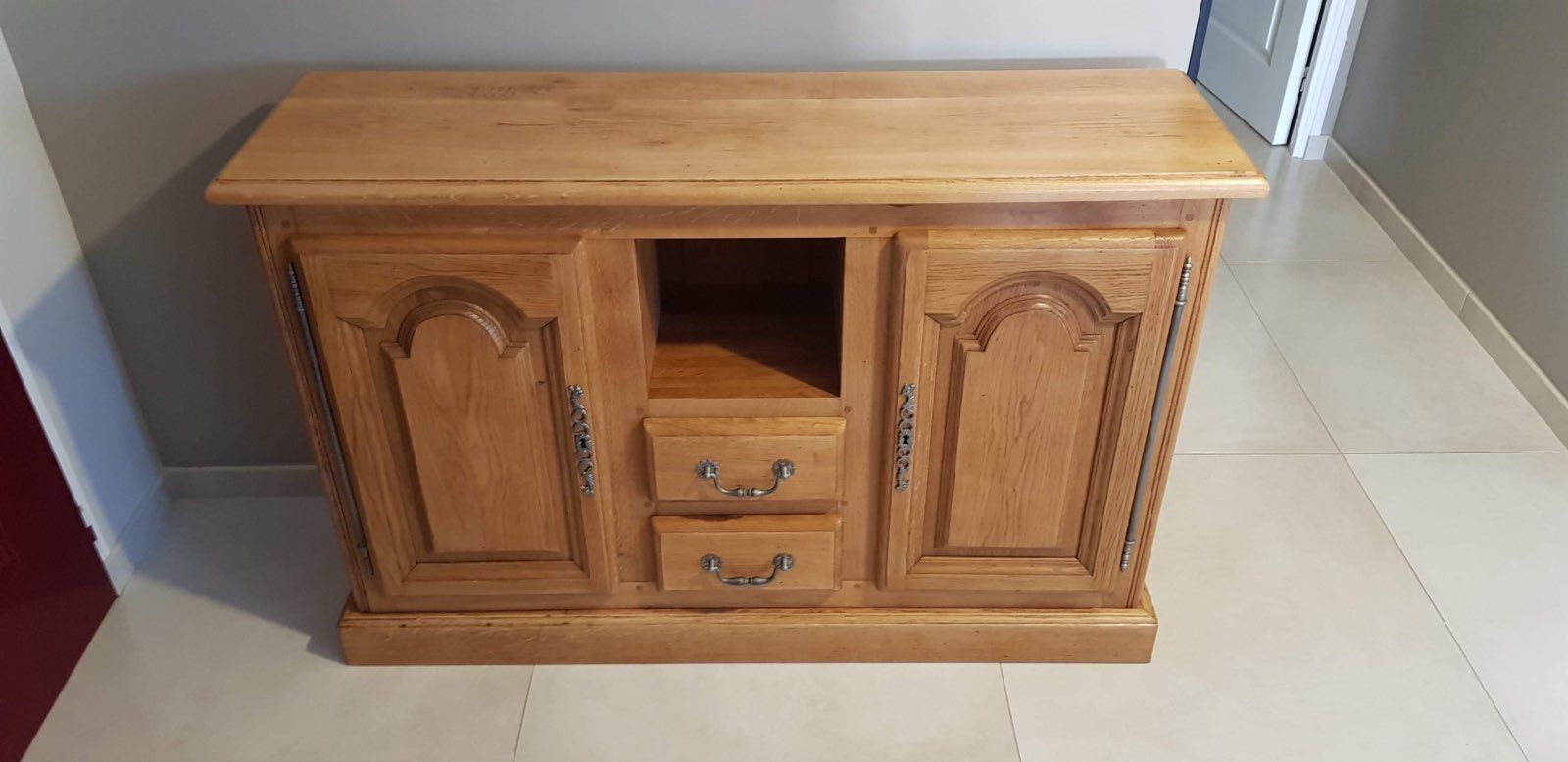 Buffet en bois clair avec plusieurs tiroirs et portes