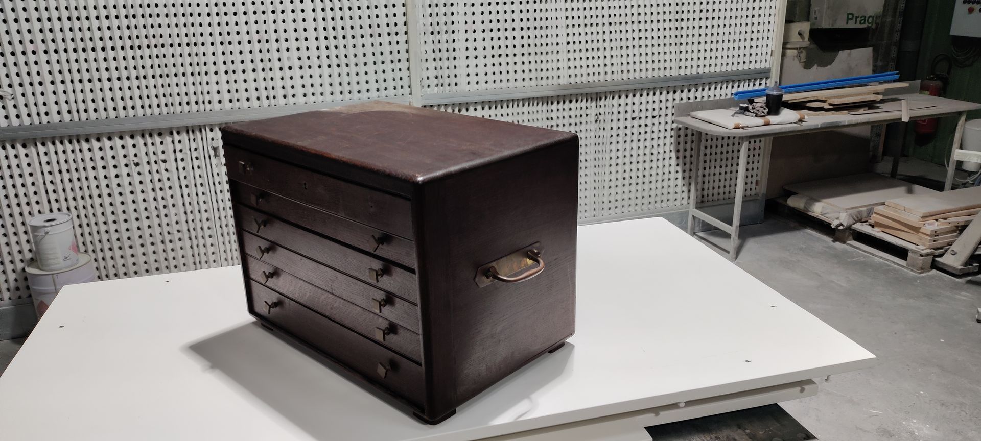 Une commode en bois brun posée sur une surface blanche