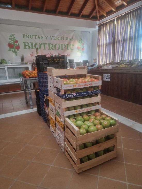En un almacén se apilan cajas de manzanas unas sobre otras.