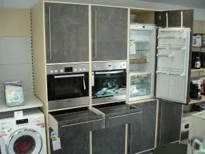 Einbauküchenwand mit Edelstahlgeräten, Schränken und offenem Kühlschrank