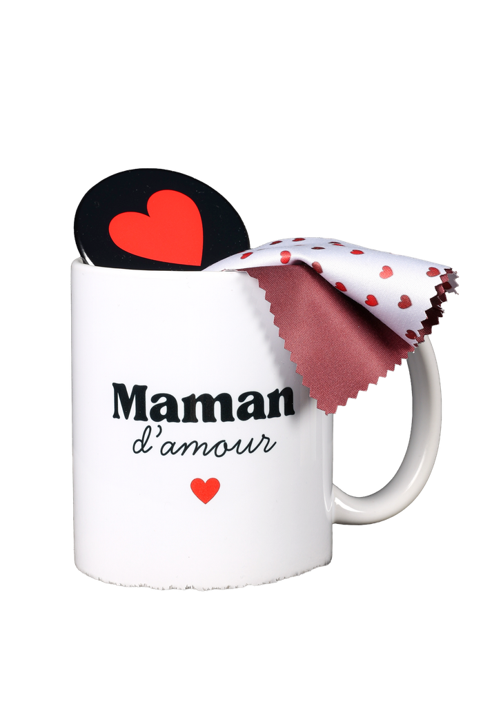 Mug blanc avec l’inscription « Maman d'amour », un cœur rouge et un tissu à motifs drapé sur le bord