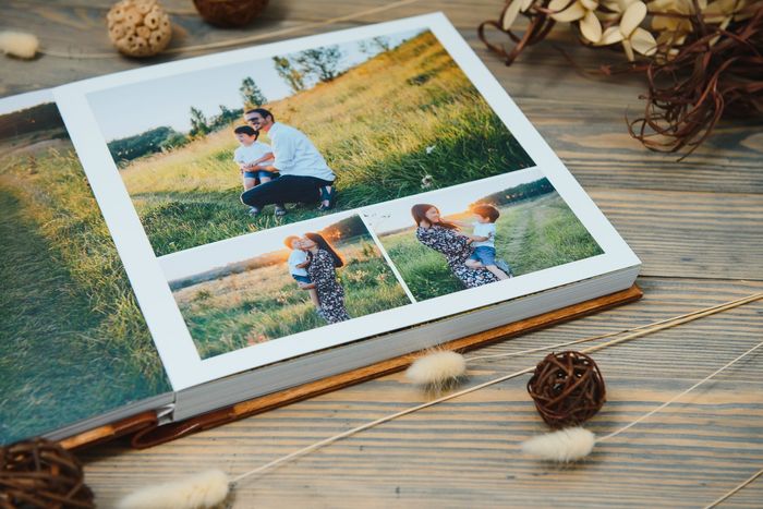 Album photo ouvert sur une table en bois, présentant des photos de famille en plein air dans un cadre rustique