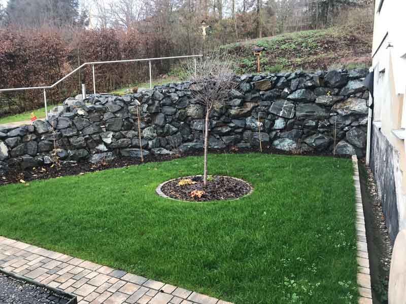 Grünfläche und Steinmauer