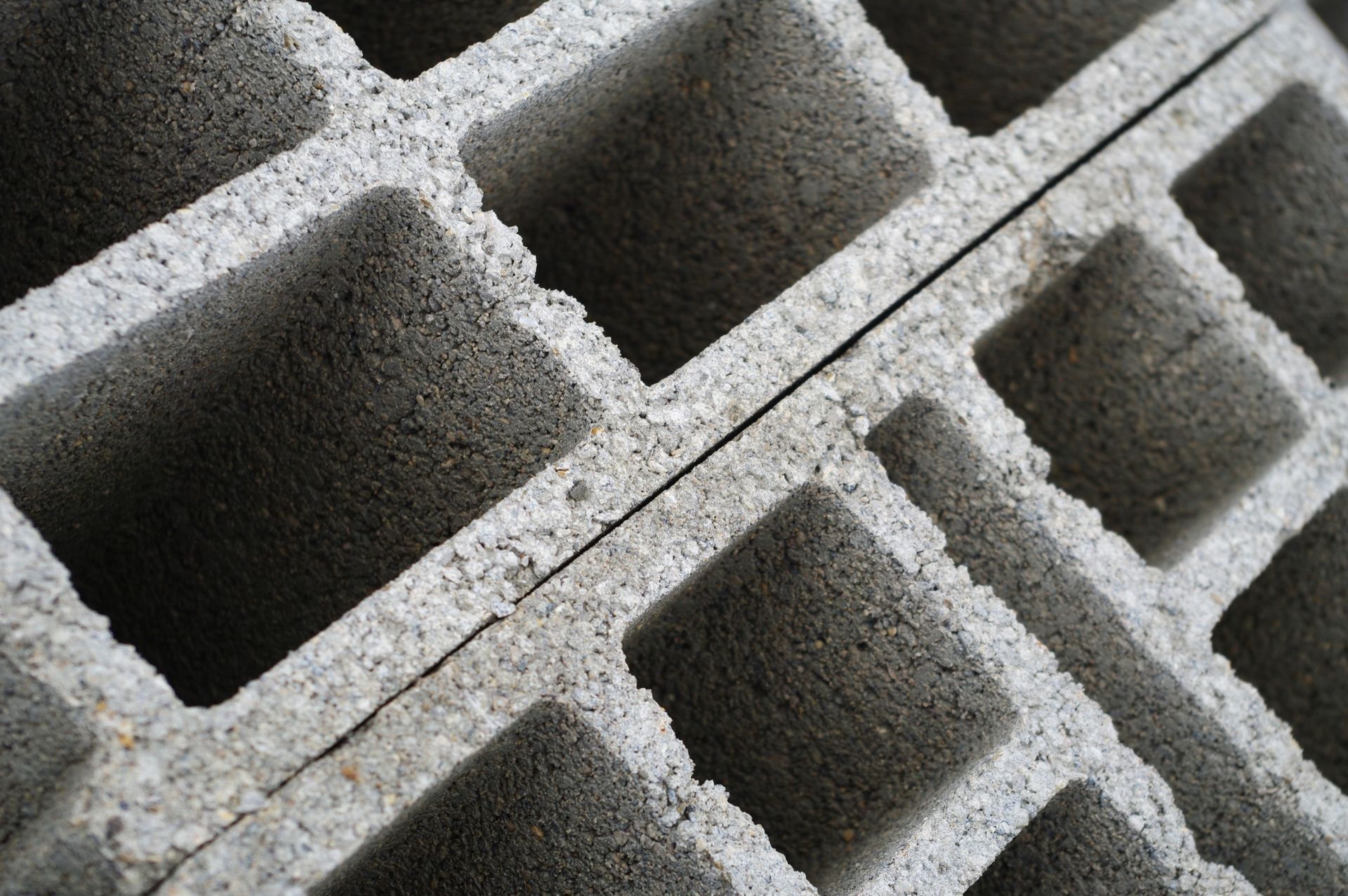 Gros plan, vue en biais de blocs de béton gris avec des chambres creuses rectangulaires visibles.