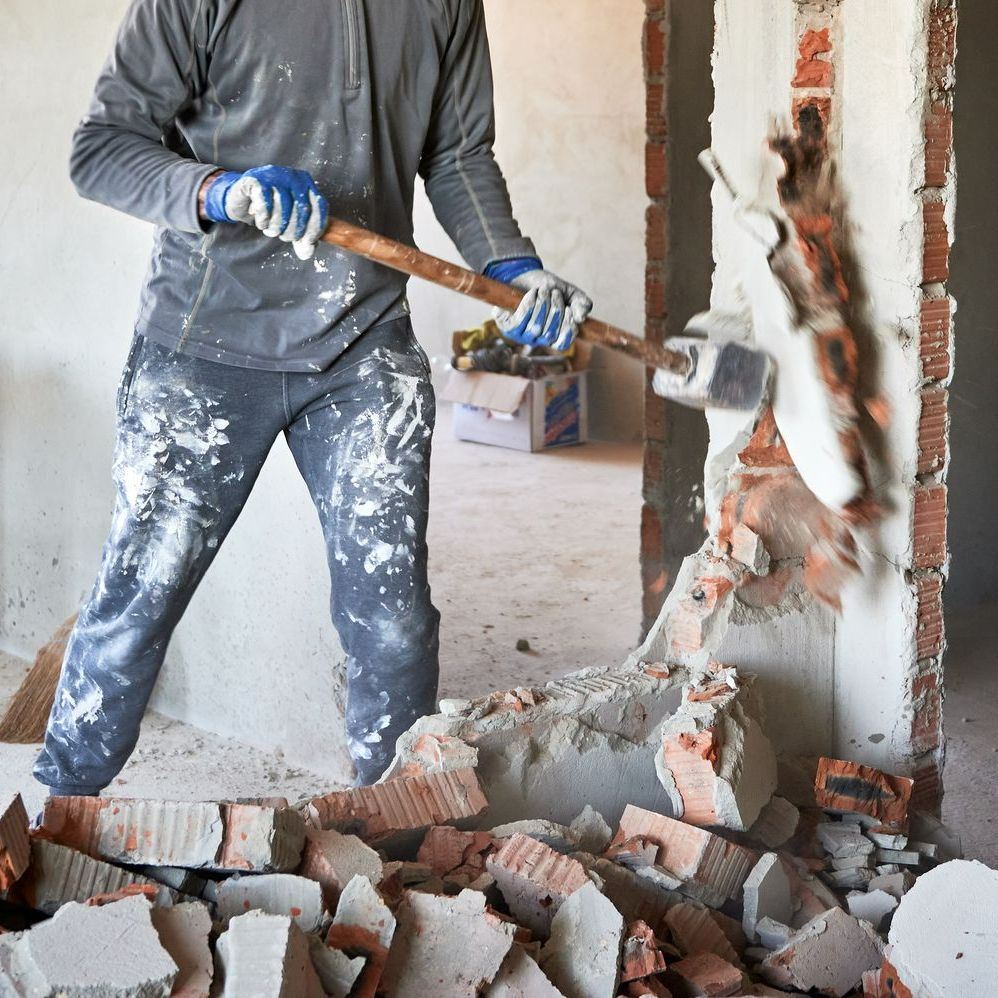 Démolition d'un mur avec une masse