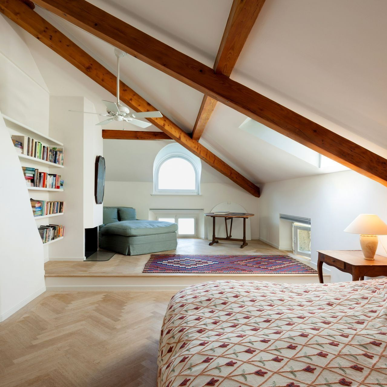 Chambre aménagée sous des combles avec poutres apparentes