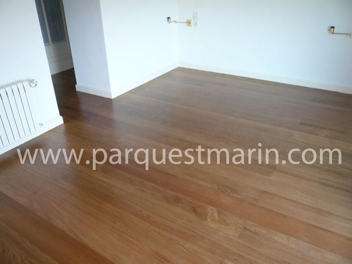 Una habitación vacía con suelo de madera y el sitio web www.parquetmarin.com