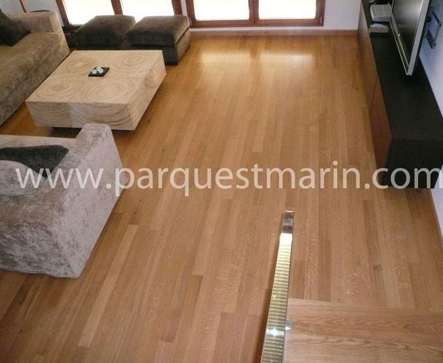Una sala de estar con suelo de madera y la página web www.parquetmarin.com