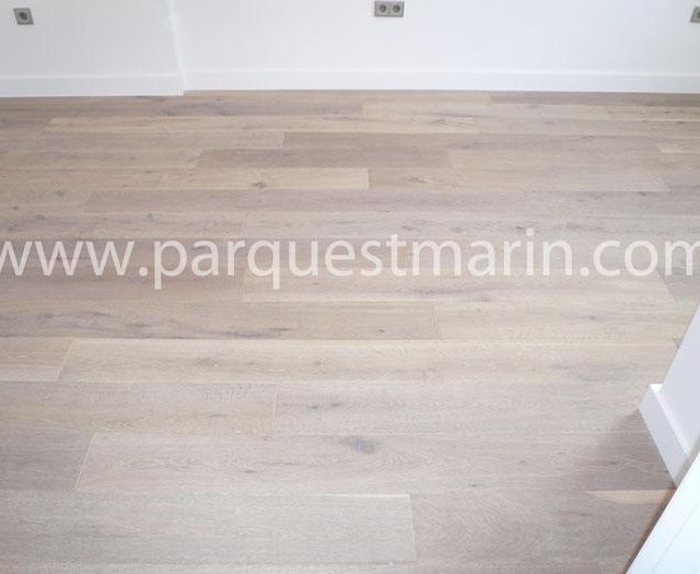 Una habitación con suelo de madera y la página web www.parquetmarin.com