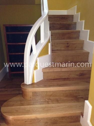 Una escalera de madera con barandilla blanca y el sitio web www.parquetmarin.com