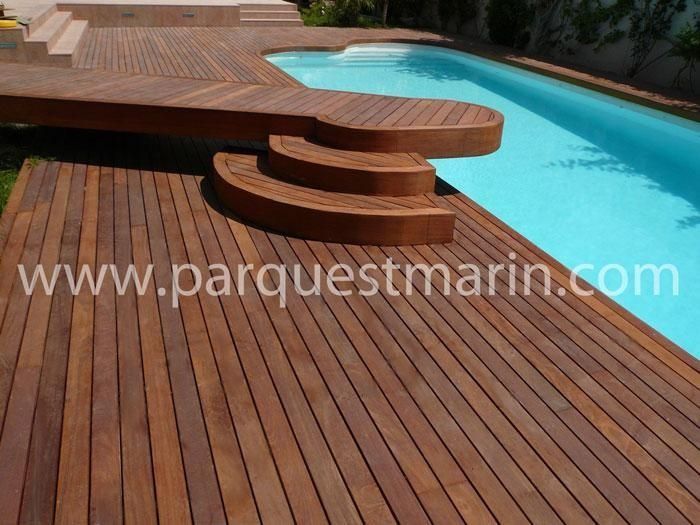 Una terraza de madera junto a una piscina con el sitio web www.parquestmarin.com