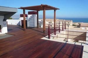 Una terraza de madera con vista al mar.