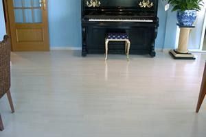 Una sala de estar con un piano y un taburete delante.