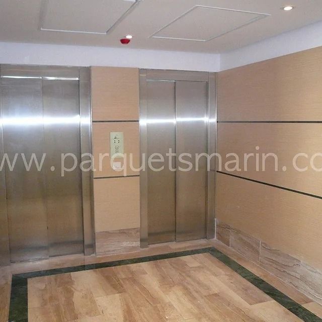 Un ascensor con el sitio web www.parquetsmarin.com en la parte inferior