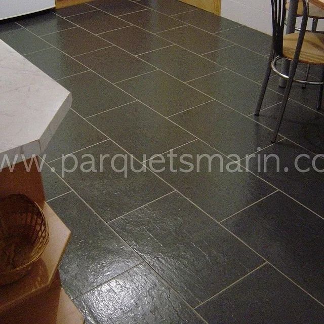 Una cocina con suelo de baldosas negras y el sitio web www.parquetsmarin.com