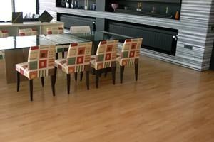 Un comedor con una mesa de cristal y sillas.