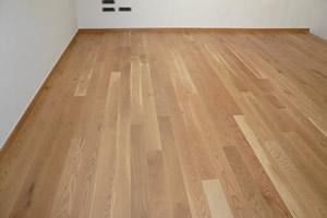 Una habitación con suelo de madera y paredes blancas.