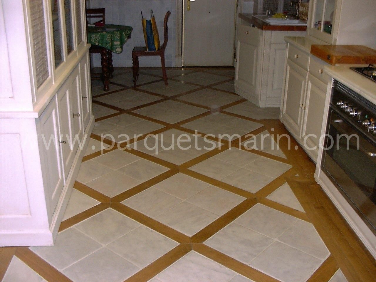 Una cocina con suelo de baldosas y la página web www.parquetsmarin.com