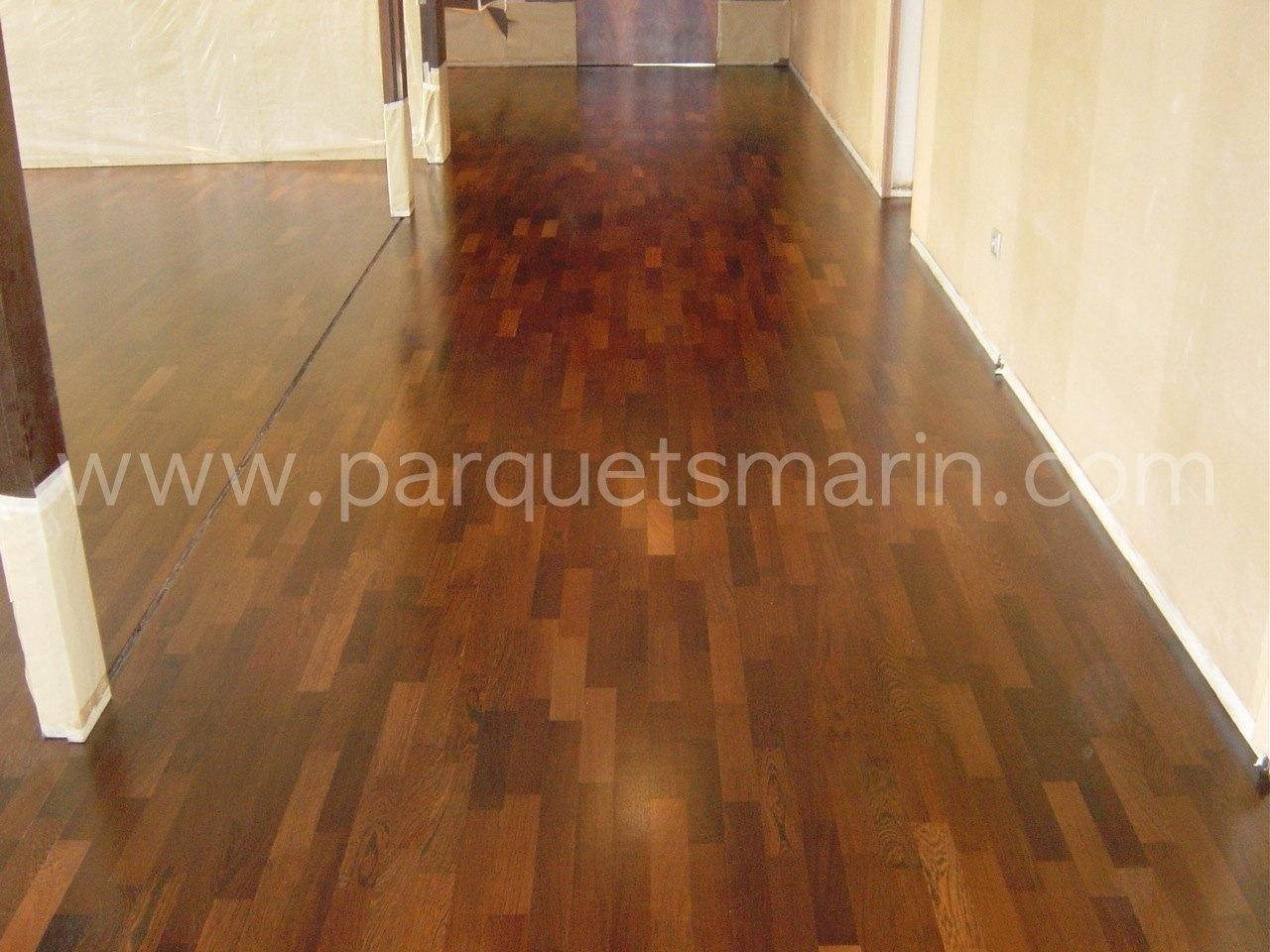 Un pasillo con suelo de madera que dice www.parquetsmarin.com