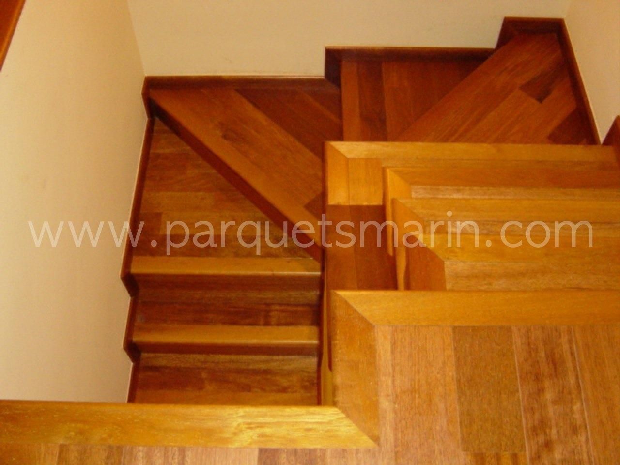Una escalera de madera con el sitio web www.parquetsmarin.com en la esquina