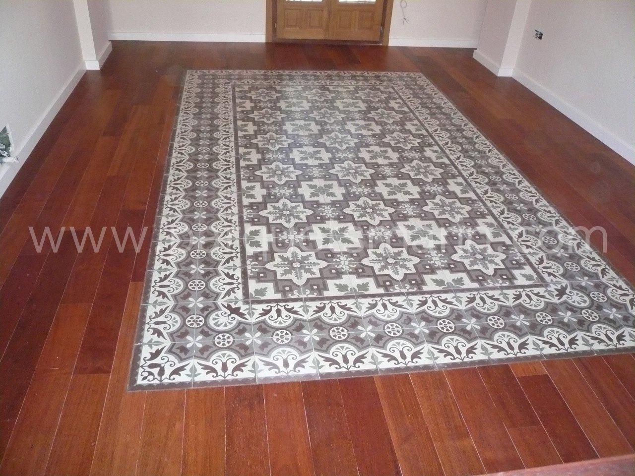 Un piso de madera con una alfombra que dice www