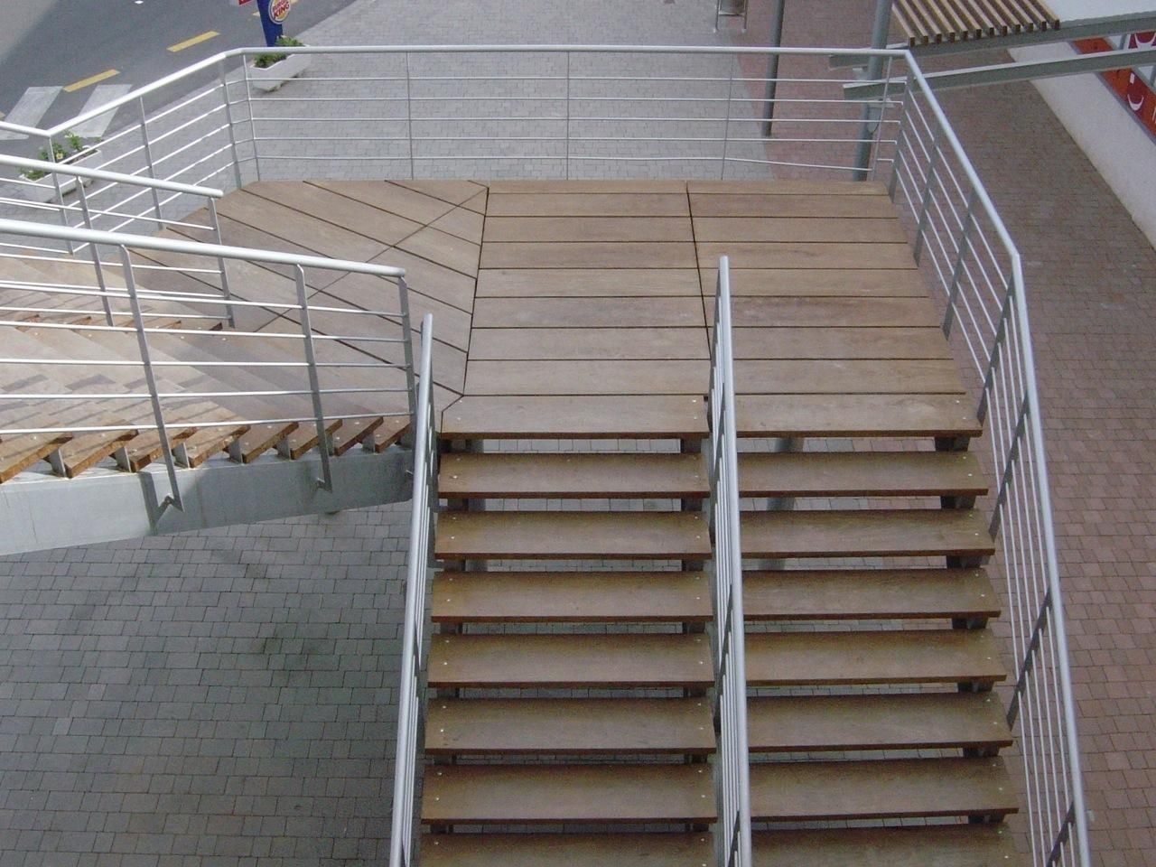 Un conjunto de escaleras de madera con barandilla de metal.