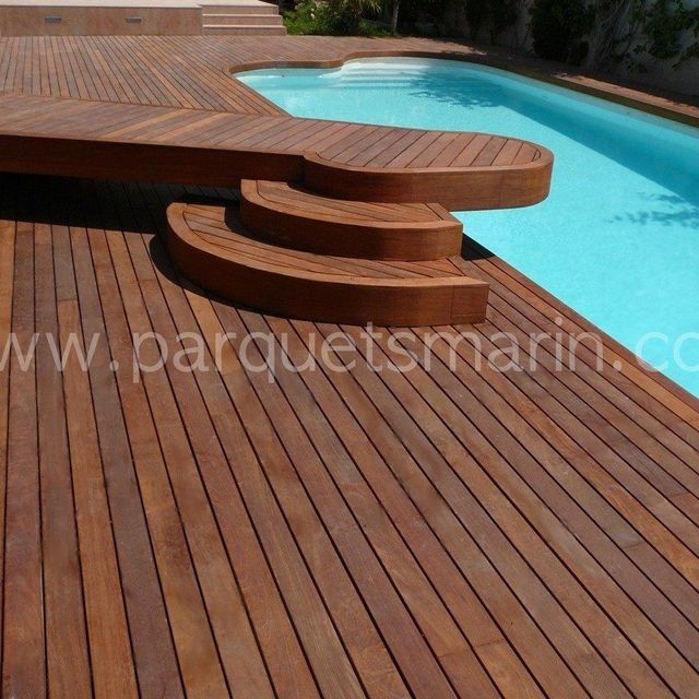 Una terraza de madera junto a una piscina con el sitio web www.parquetsmarin.com visible