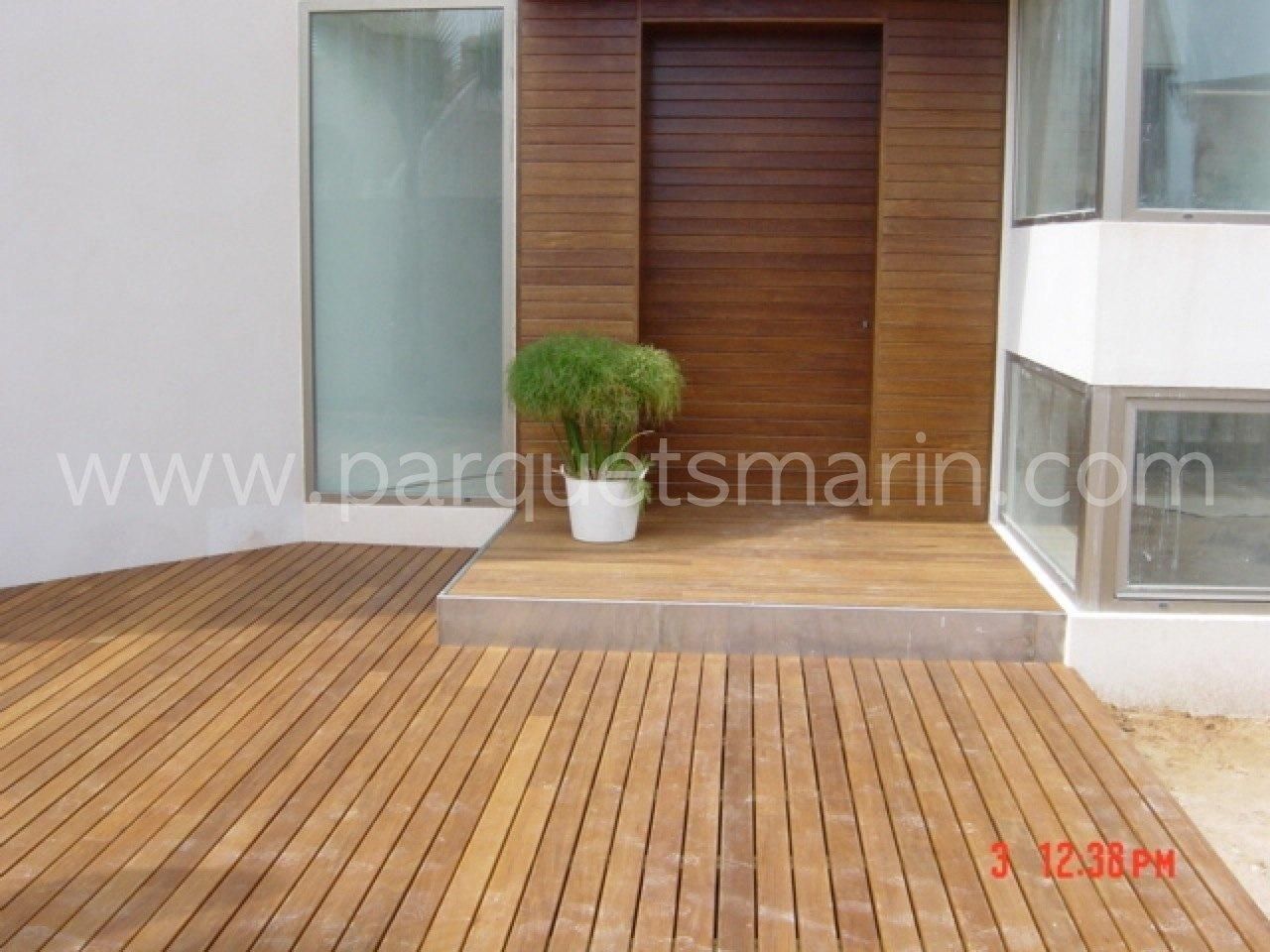 Una terraza de madera delante de una casa con el sitio web www.parquetsmarin.com visible