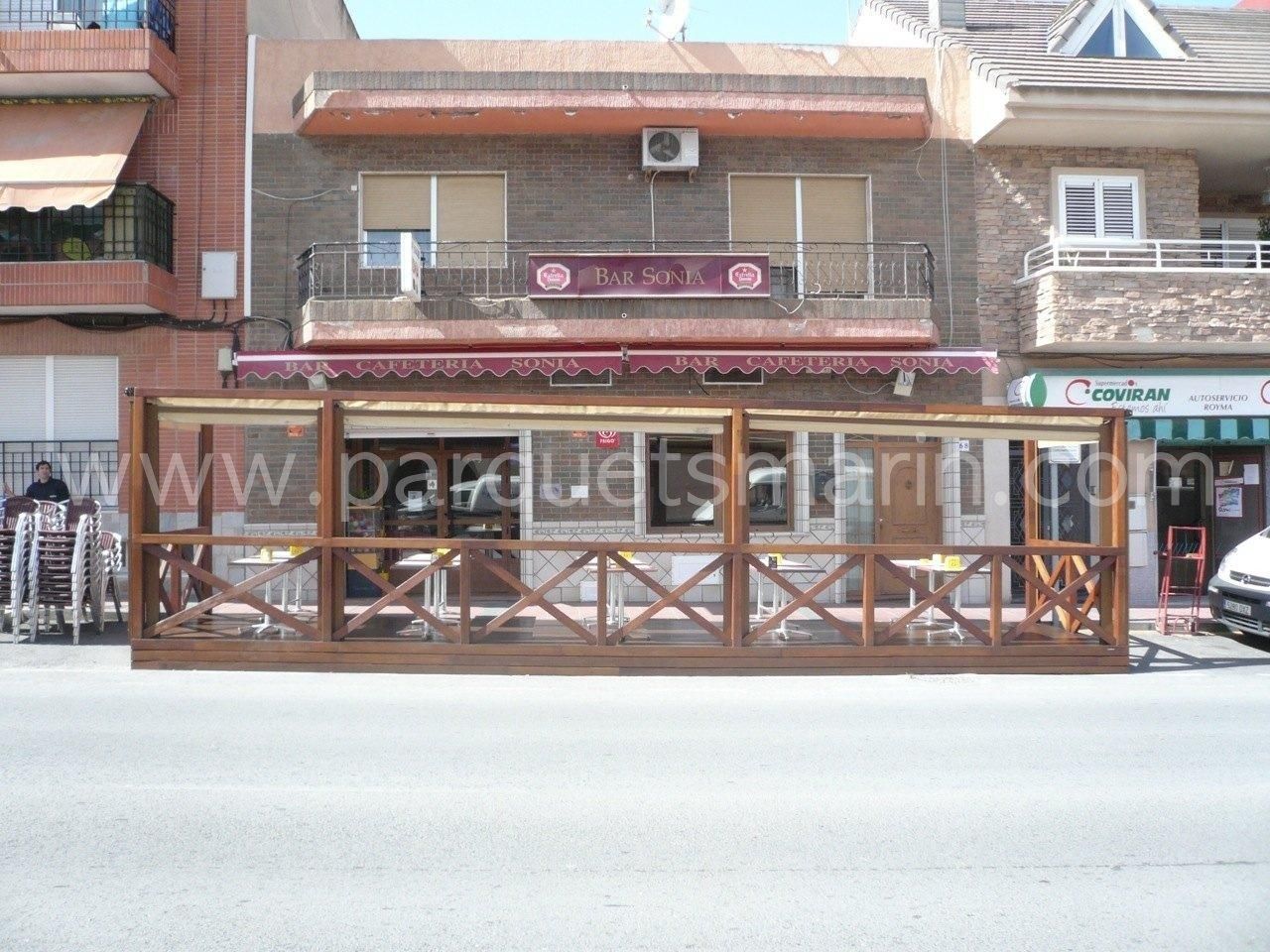 Un restaurante con una valla de madera delante.