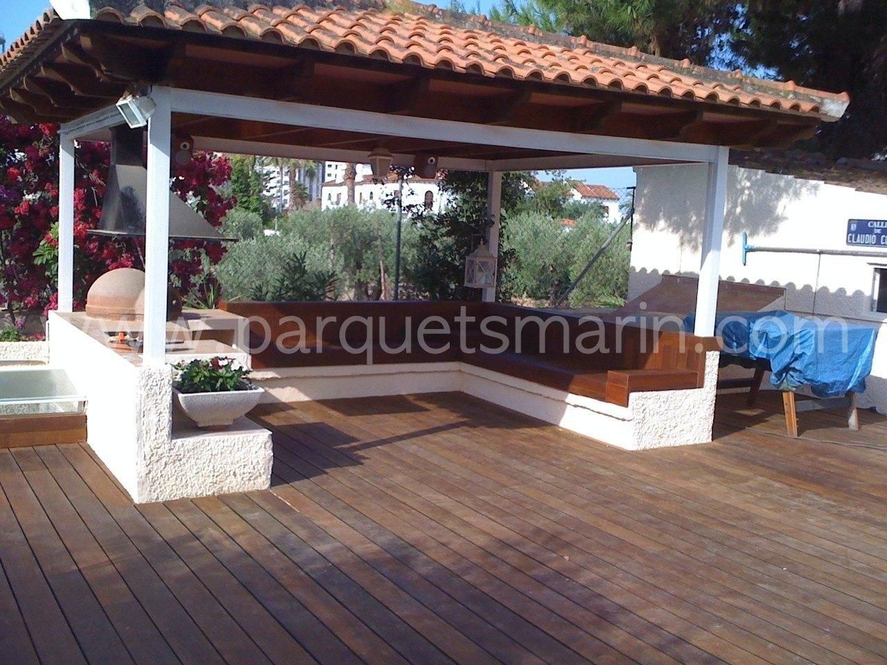 Una terraza de madera con cenador y el sitio web parquetsmarin.com