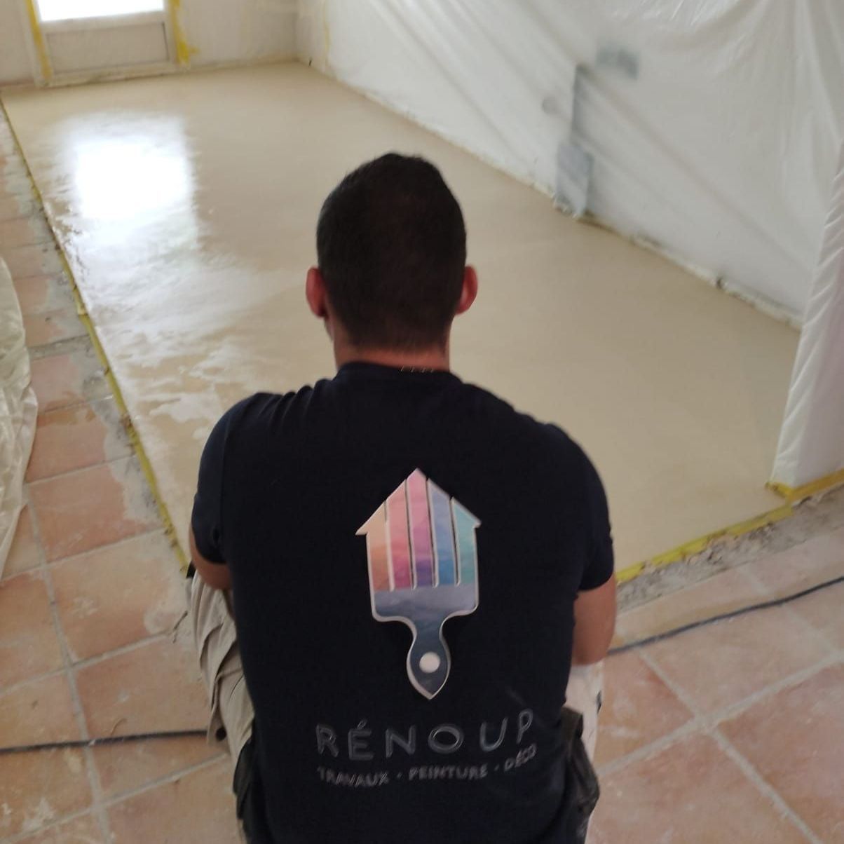 Un homme portant une chemise Renoup est assis sur le sol