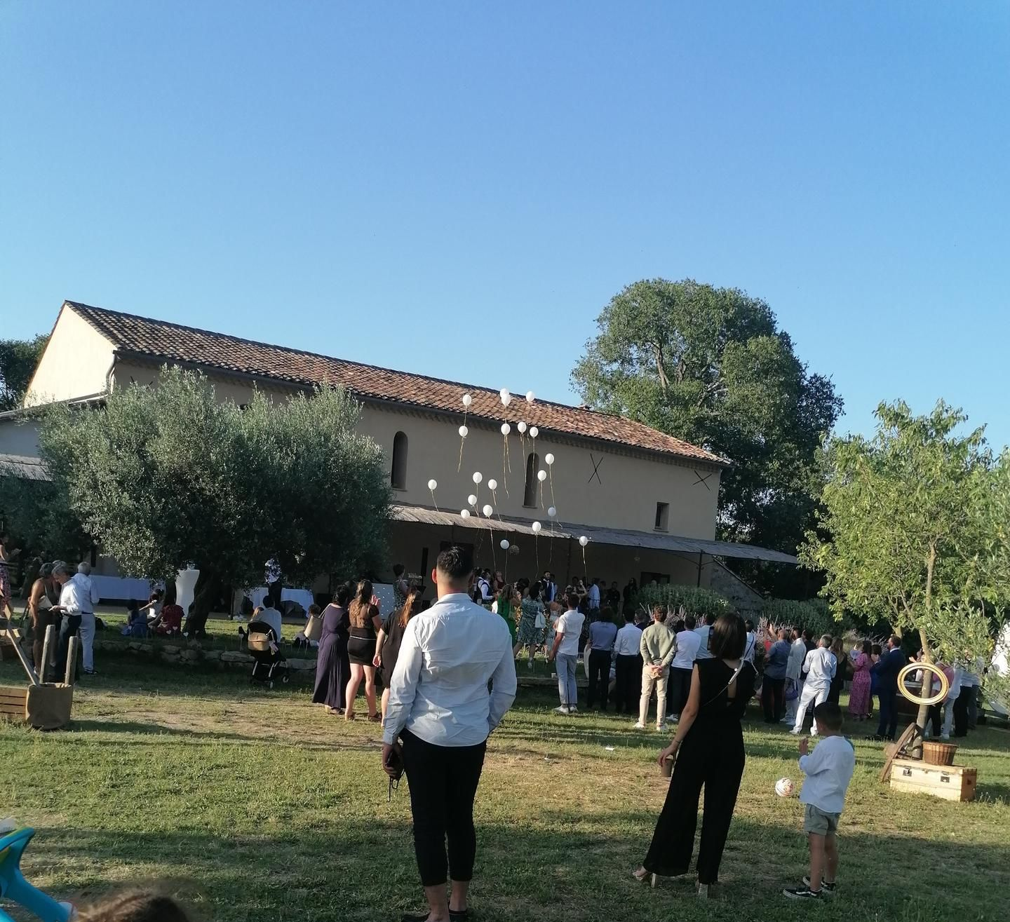 Des gens se sont rassemblés à l'extérieur, près d'un bâtiment pour un lâché de ballons.