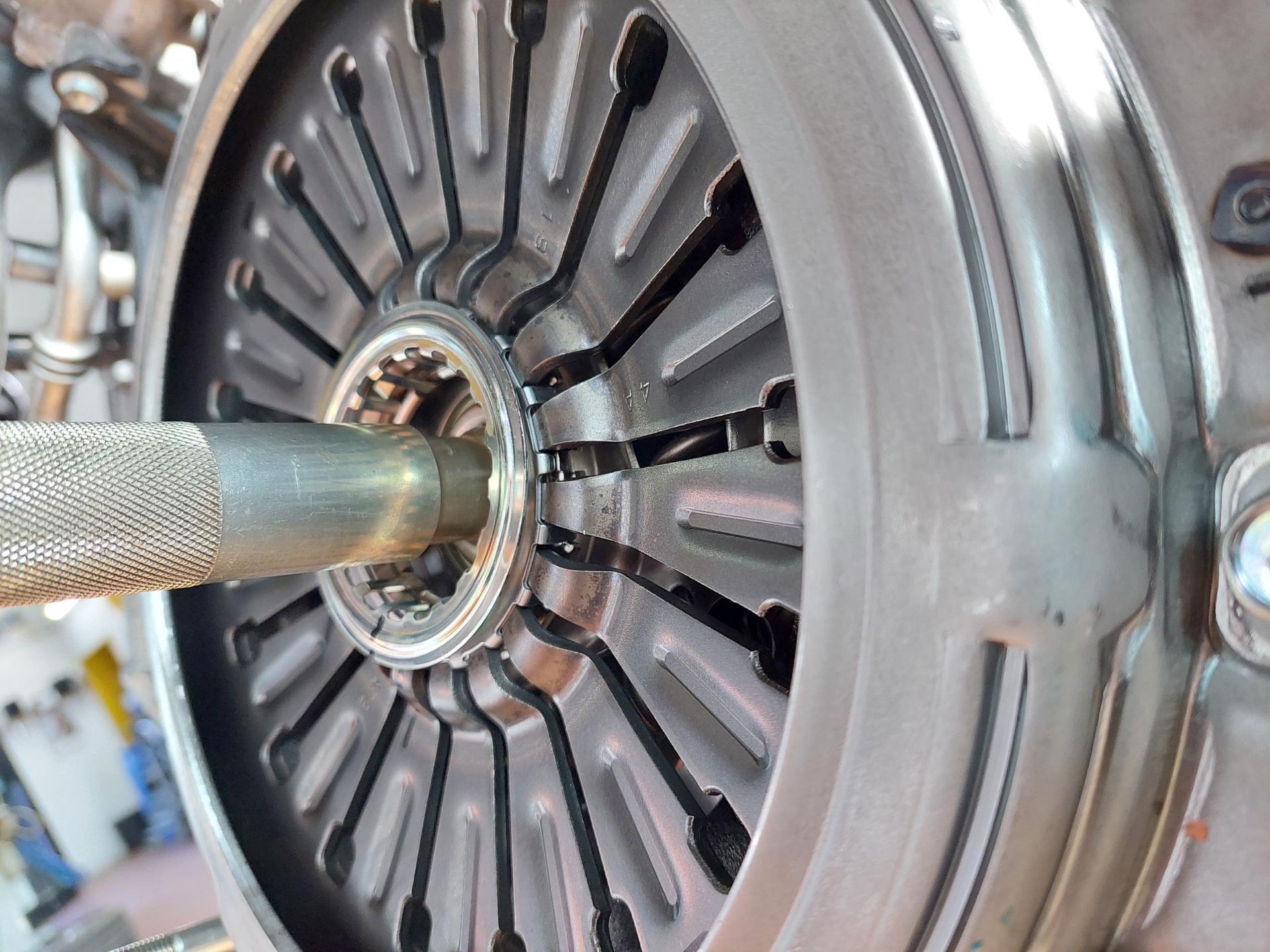 Ein Mann wechselt in einer Garage einen Reifen an einem roten Auto.