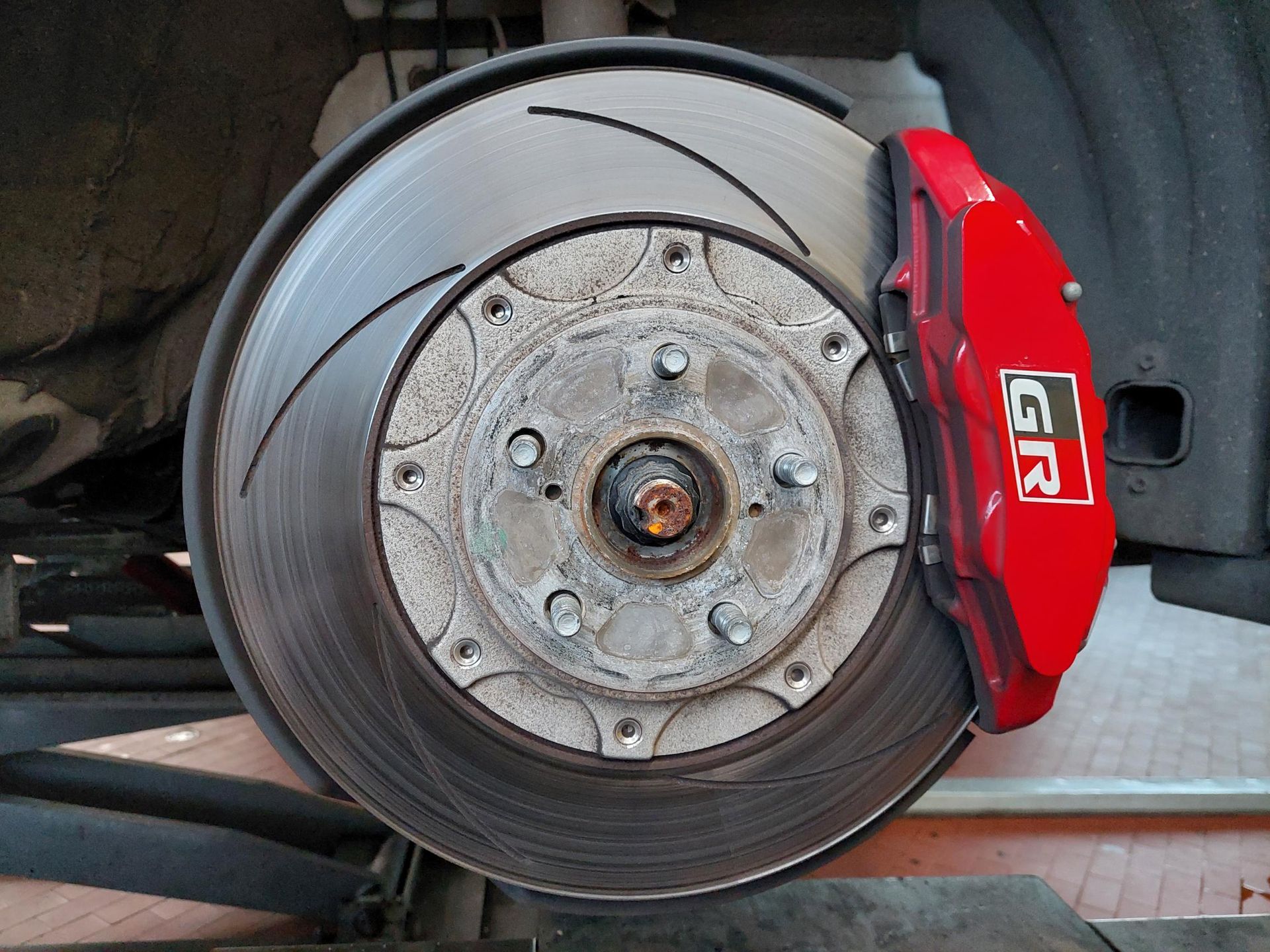 Ein Mann arbeitet in einer Garage an der Unterseite eines Autos.