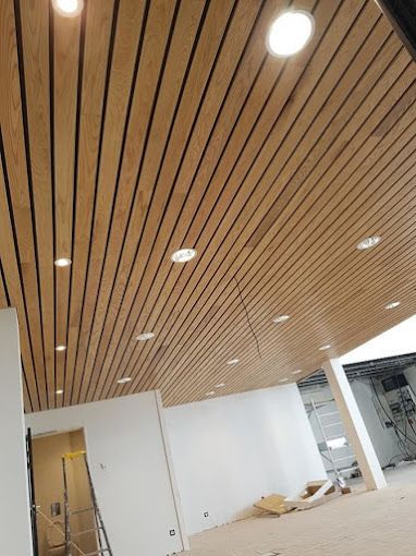 Une pièce avec un plafond en bois et beaucoup de lumières.