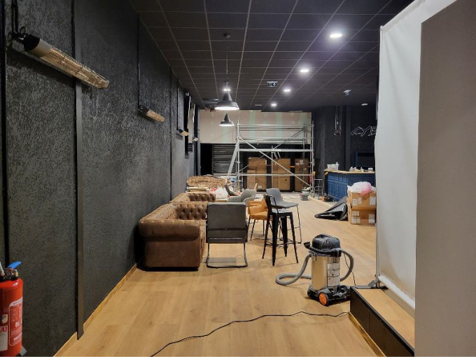 Une pièce avec un canapé, des chaises et un aspirateur