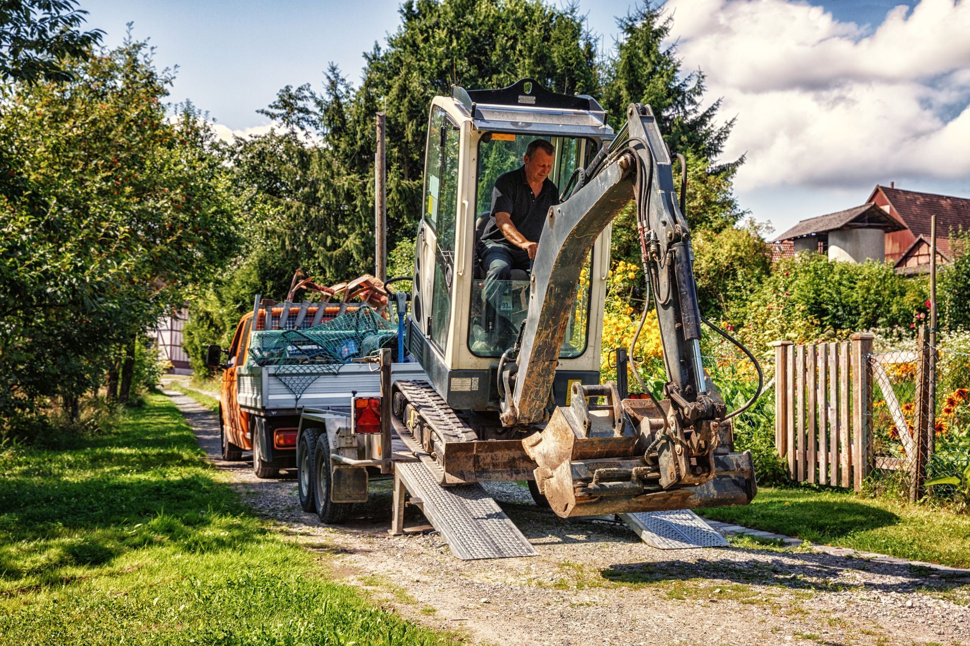 Minipelle qui descend de la remorque d'un porte-engin