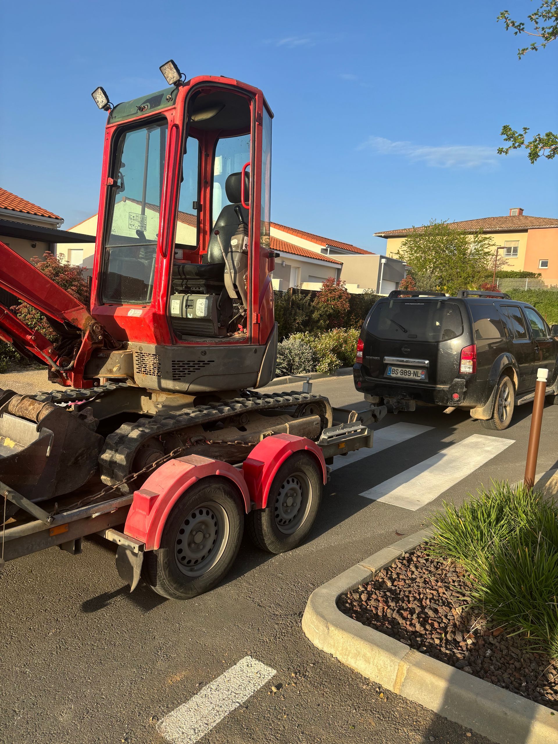 Minipelle sur une remorque de porte-engin